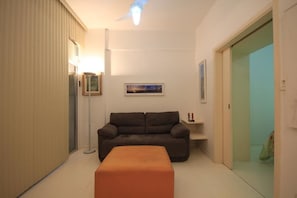 A compact living room with a sofa, a small side table, and a floor lamp.