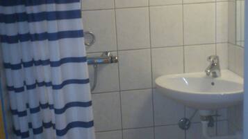 Un baño con ducha, lavamanos e inodoro.
