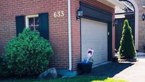A residential building with a garage door, a mailbox, and a number '633' on the side. - Cobblestone Bed and Breakfast (Niagara-on-the-Lake)