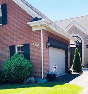 A residential building with a garage door, a mailbox, and a number '633' on the side. - Cobblestone Bed and Breakfast (Niagara-on-the-Lake)
