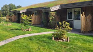 A row of modern cabins with sloped roofs, wooden fences, and small trees in front. - Landhotel Diever (Diever)