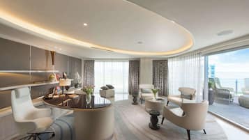 A modern hotel room with a curved ceiling, a round dining table, a sofa, and a balcony with a view.
