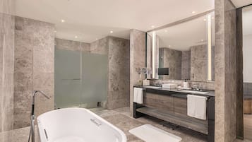 A modern bathroom with a freestanding bathtub, a walk-in shower, and a vanity with a large mirror.