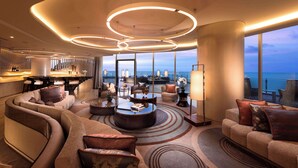 A modern hotel lobby with a curved sofa, round coffee table, and a bar area. - Conrad Manila (Pasay)