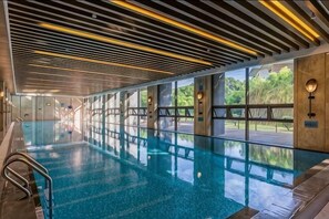 A swimming pool with a modern design, large windows, and a view of the outdoors. - Longtan Lake Hotel (Shangrao)