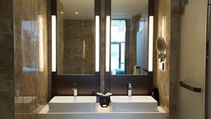 A modern bathroom with two sinks, a large mirror, and a shower area. - Longtan Lake Hotel (Shangrao)
