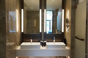 A modern bathroom with two sinks, a large mirror, and a shower area. - Longtan Lake Hotel (Shangrao)