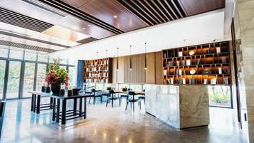 A spacious lobby with a reception desk, seating area, and a large bookshelf.