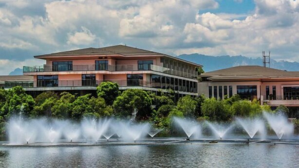 A modern building with a flat roof, large windows, and a water fountain in front. - Longtan Lake Hotel (Shangrao)