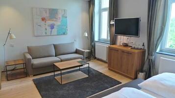 A modern, well-lit room with a sofa, a coffee table, a TV, and a cabinet.