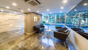 A modern lobby with a marble floor, seating area, and large windows offering a view of the outdoors. -  Monapart Hotel Istanbul Mecidiyekoy (Istanbul)