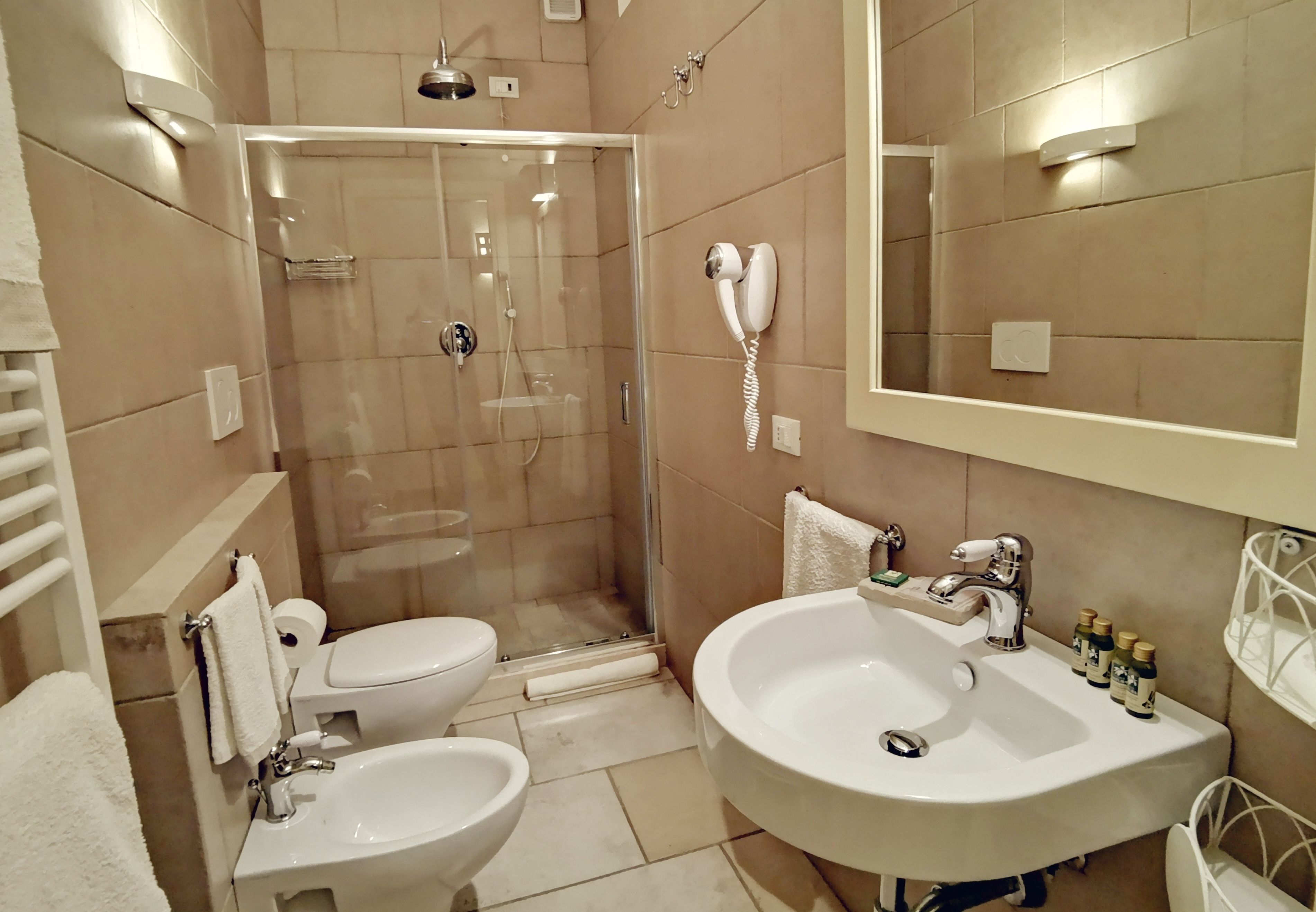 A modern bathroom with a glass-enclosed shower, a large sink, and a toilet.
