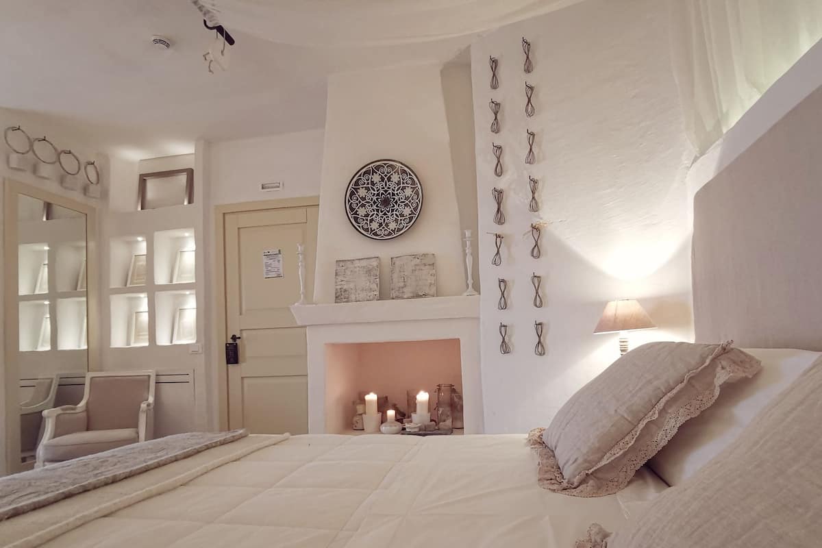 Ein Schlafzimmer mit Bett, Kamin und Wanddekorationen.