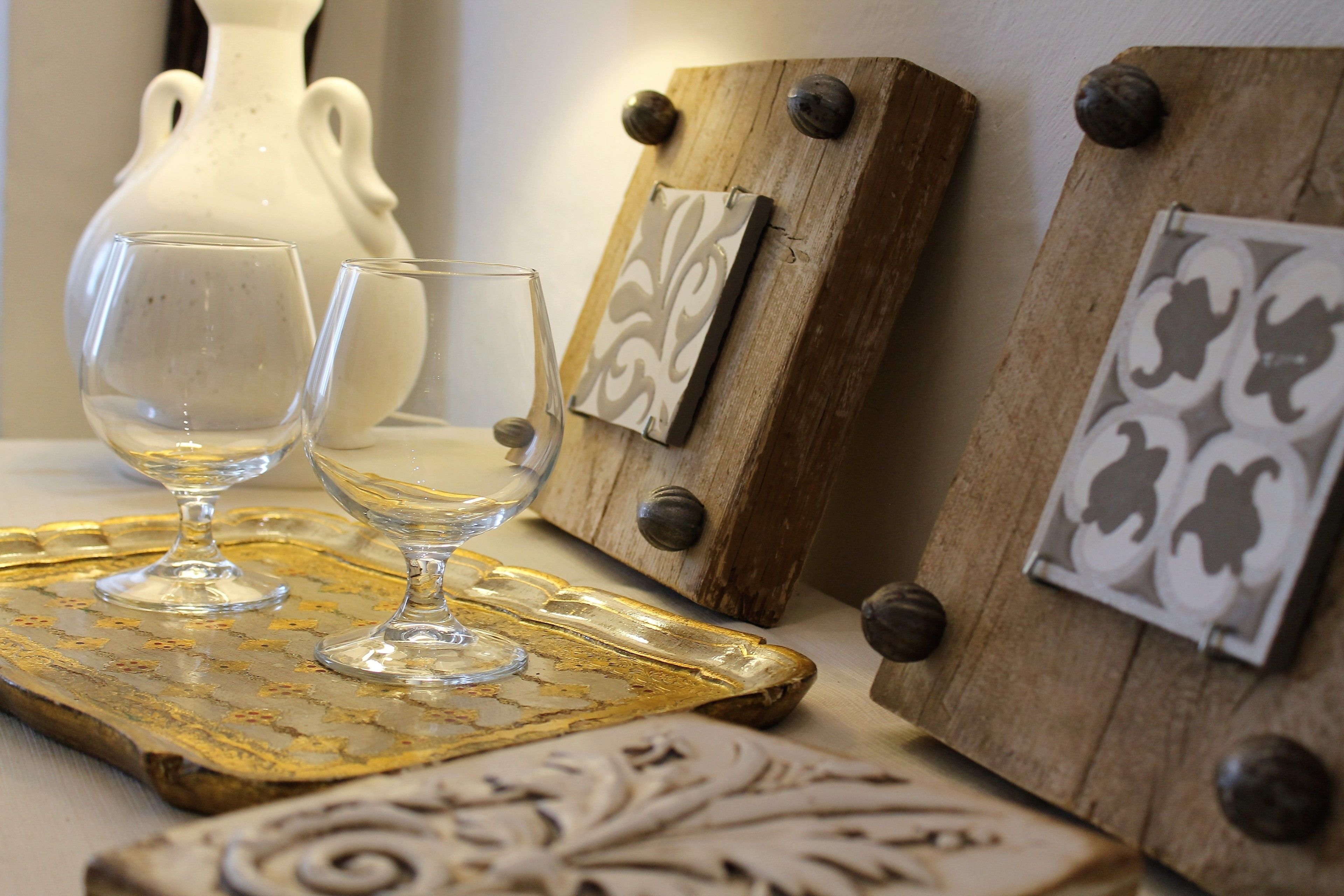 Une table avec deux verres à vin et un plateau décoratif.
