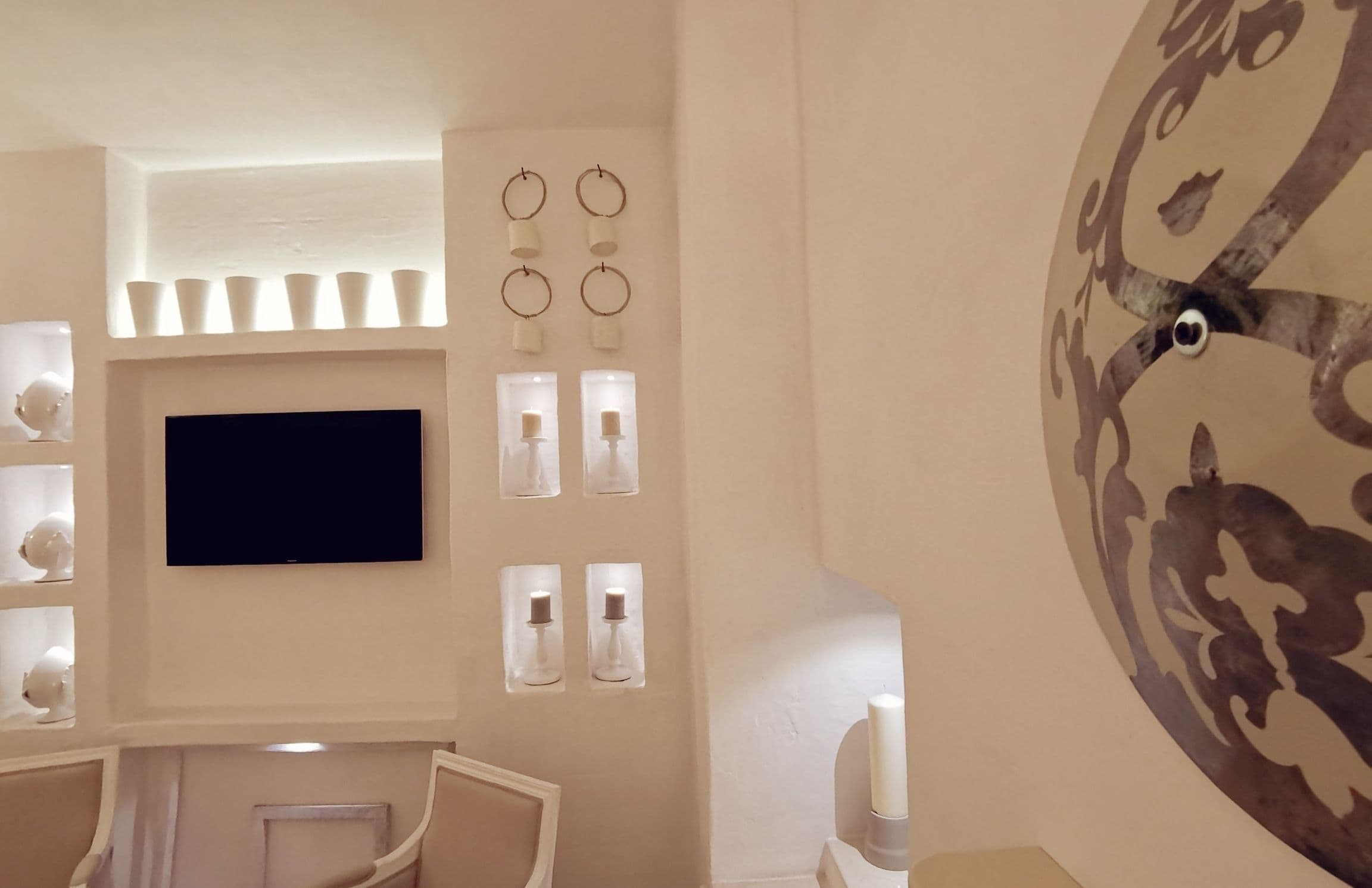 Um interior moderno com uma TV de tela plana na parede, uma série de luzes decorativas e um grande mural.