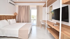 A modern hotel room with a large bed, a TV, and a balcony with curtains. - Olympion Melathron (Dio-Olympos)