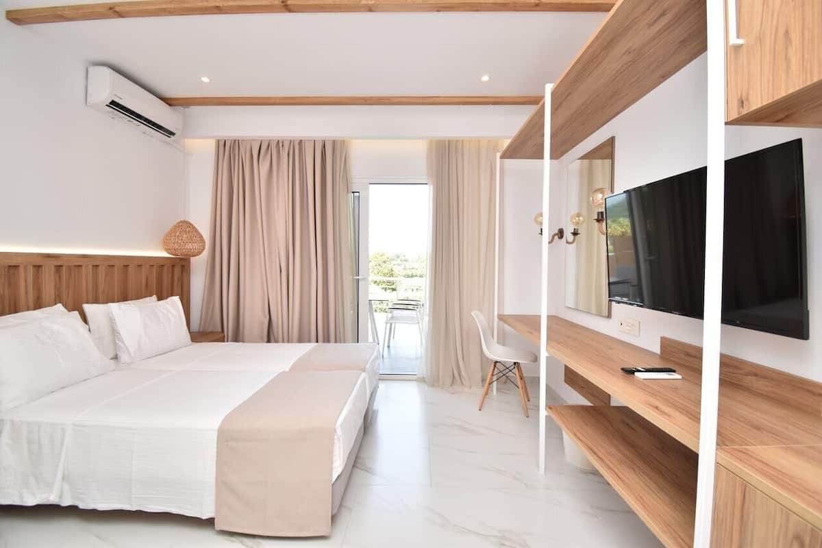 Una habitación de hotel moderna con una cama grande, un televisor y un balcón con cortinas.
