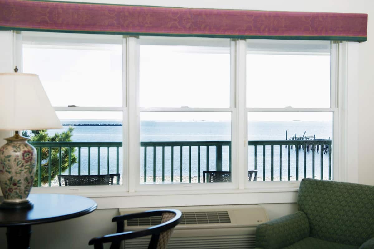Une pièce avec vue sur la mer, une table avec une lampe, une chaise et un canapé.