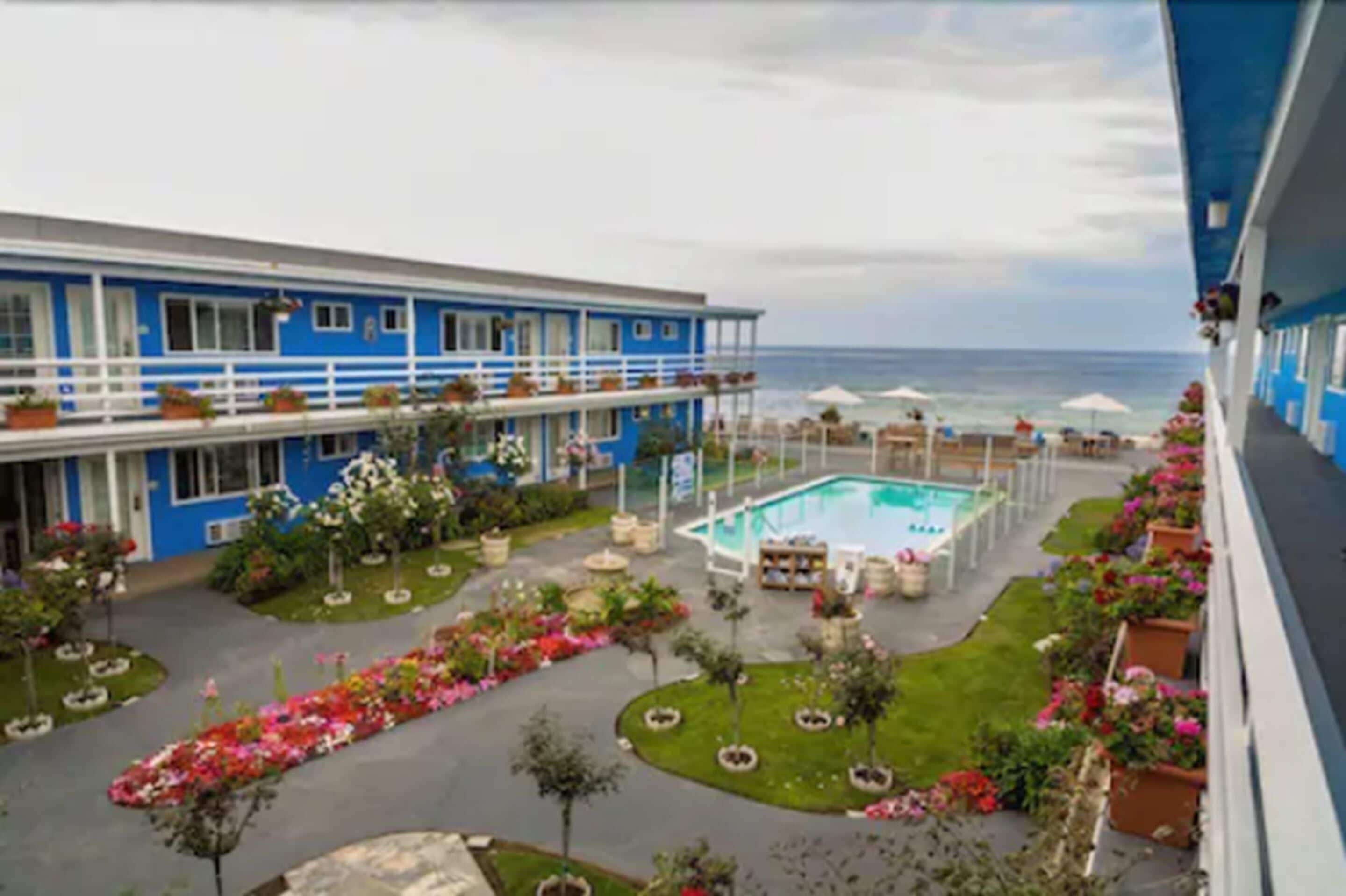 Un hotel con piscina, mobiliario exterior y vista al océano.