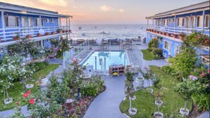 Ett hotell med pool, utomhusservering och utsikt över havet.