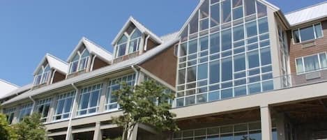 A modern multi-story building with large windows and a stone facade.