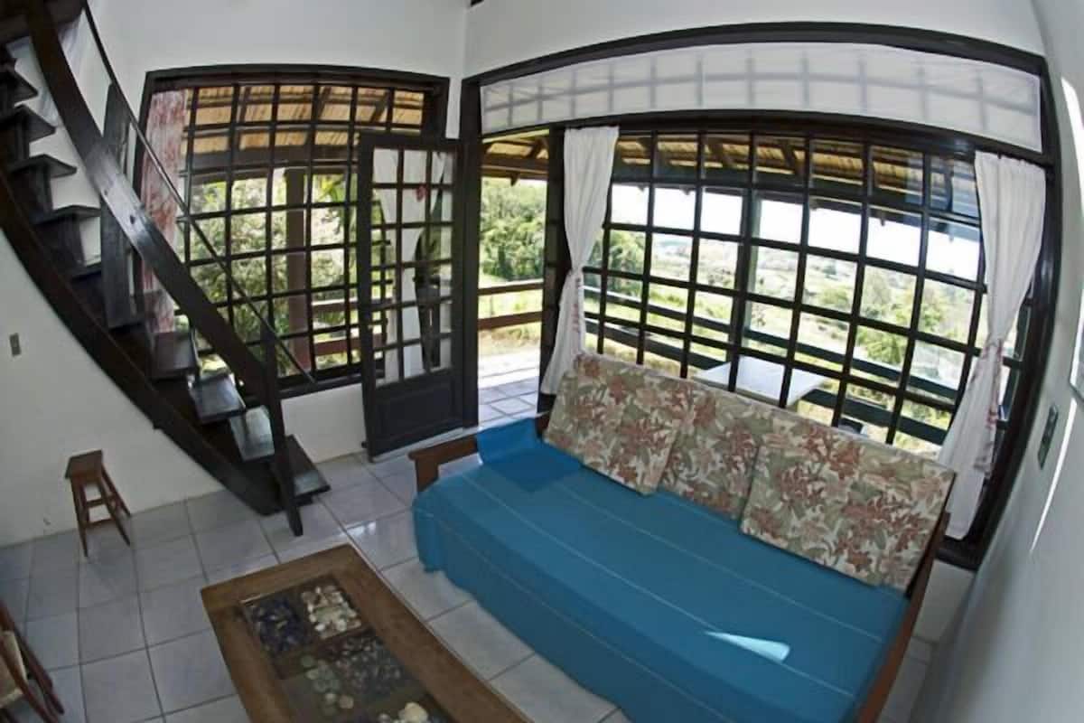 A living room with a blue sofa, a wooden coffee table, and a staircase.