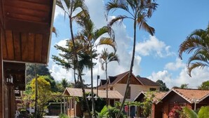 Un resort con diversi edifici in stile bungalow, una piscina e un giardino curato con diverse piante e fiori.