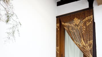A wooden door with a glass panel and a decorative curtain.