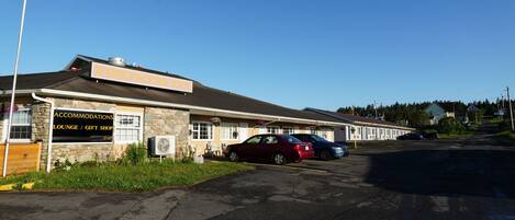 A building with a sign for 'Fortress Inn' and 'Accommodations Lounge / Gift Shop'. There are cars parked in front.