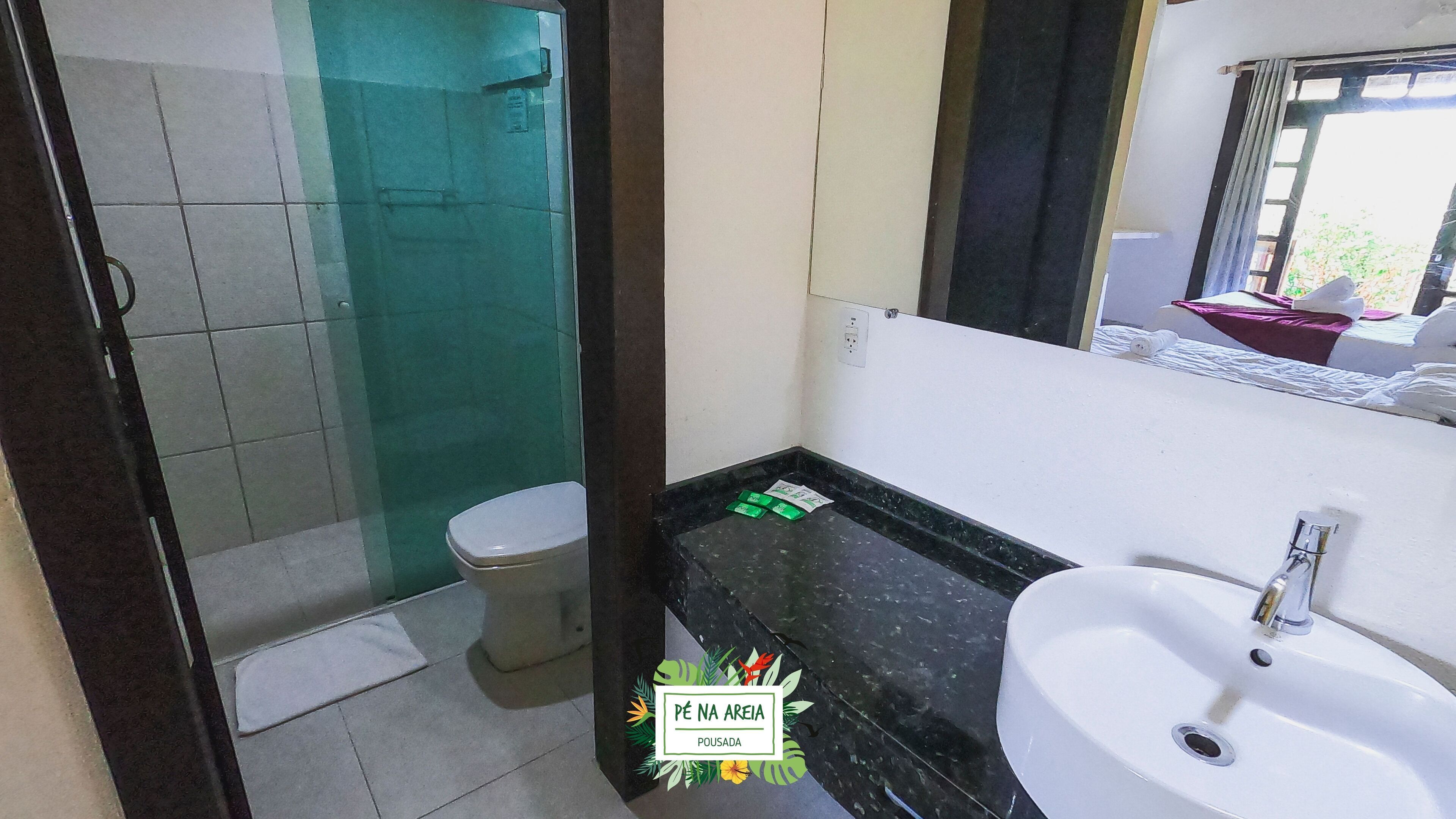 A bathroom with a toilet, a sink, and a shower area.