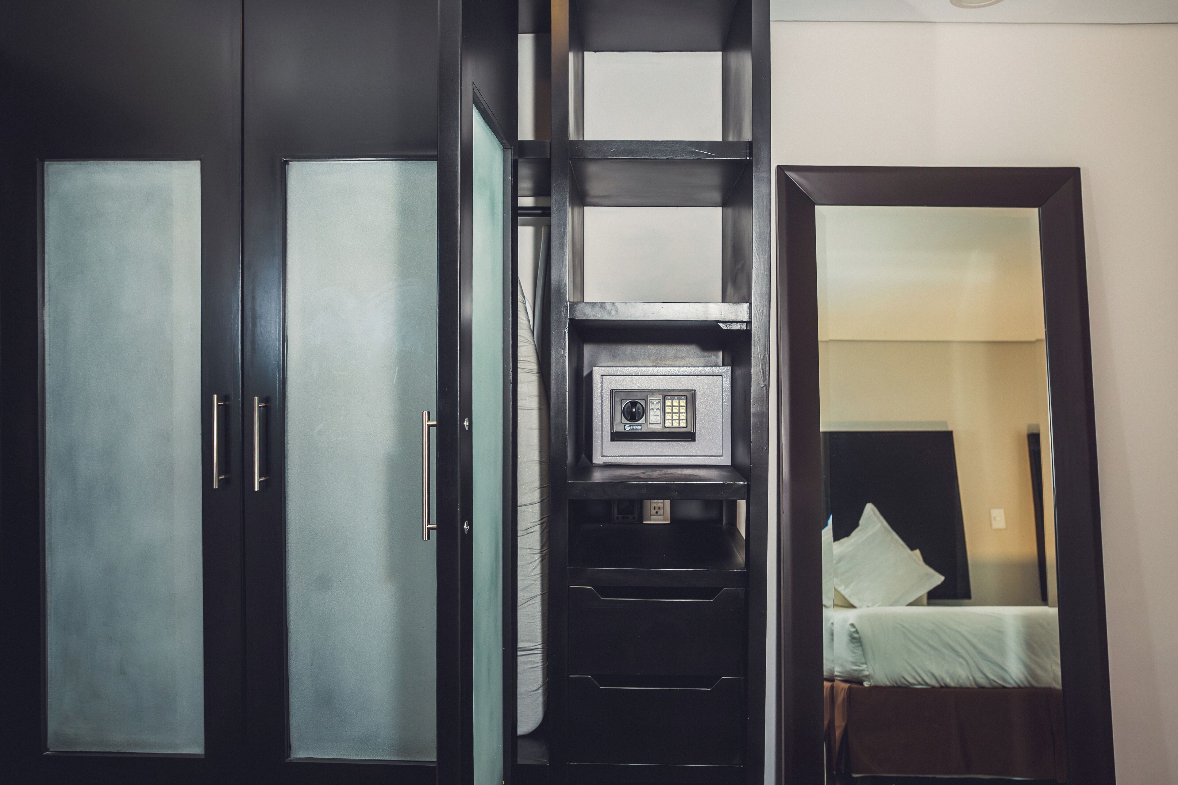 A hotel room with a bed, a wardrobe, and a built-in safe.