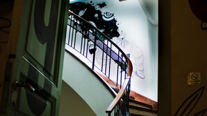 A staircase with a metal railing, a door with a large number '9' sign, and a window with a grid pattern. - Art Factory Soho (Buenos Aires)