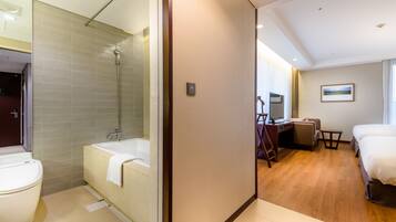 A hotel room with a shower, toilet, and a bed.