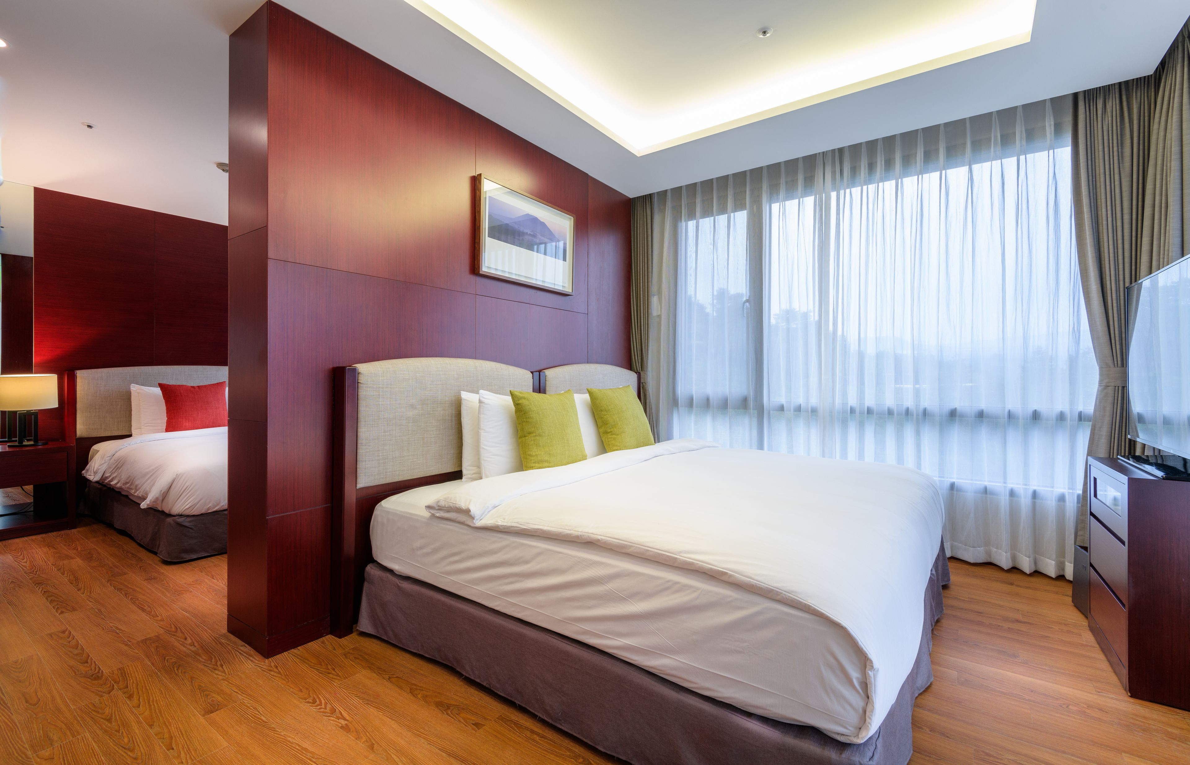 A hotel room with a large bed, a desk, and a TV.