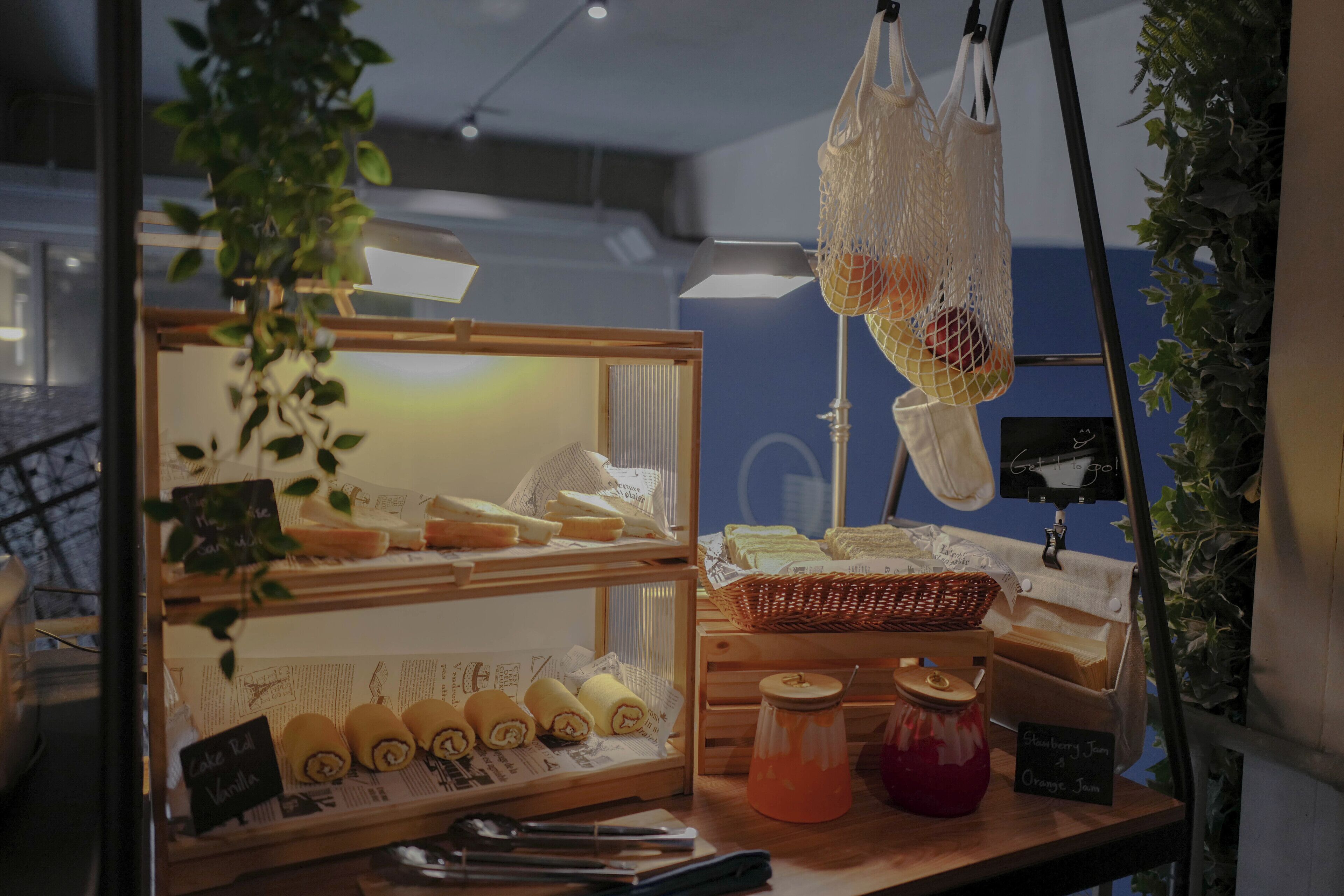 Mostrador de pastelería con pasteles, una cesta y botes de mermelada.