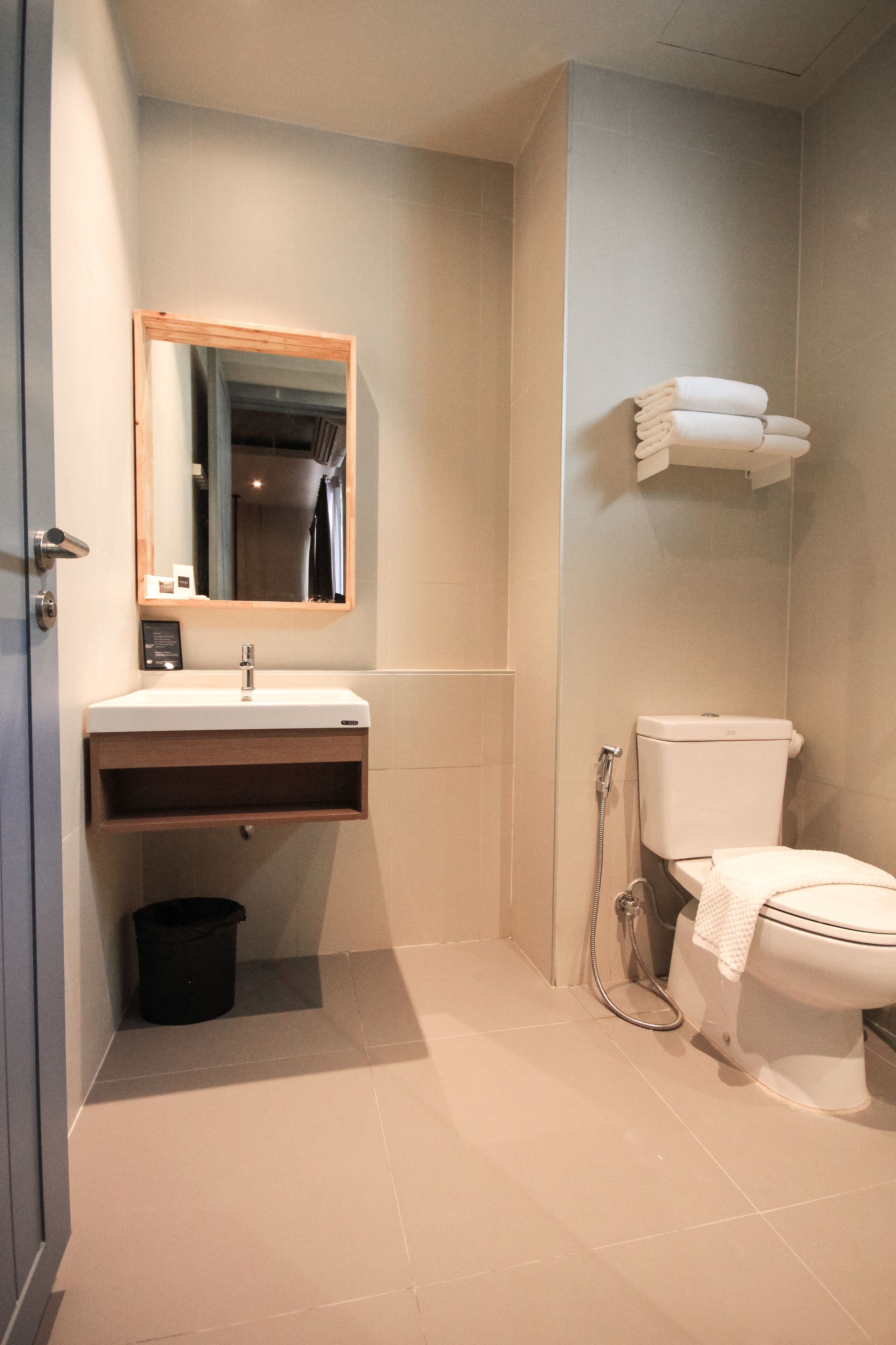 Un baño moderno con lavamanos, espejo, inodoro y ducha.