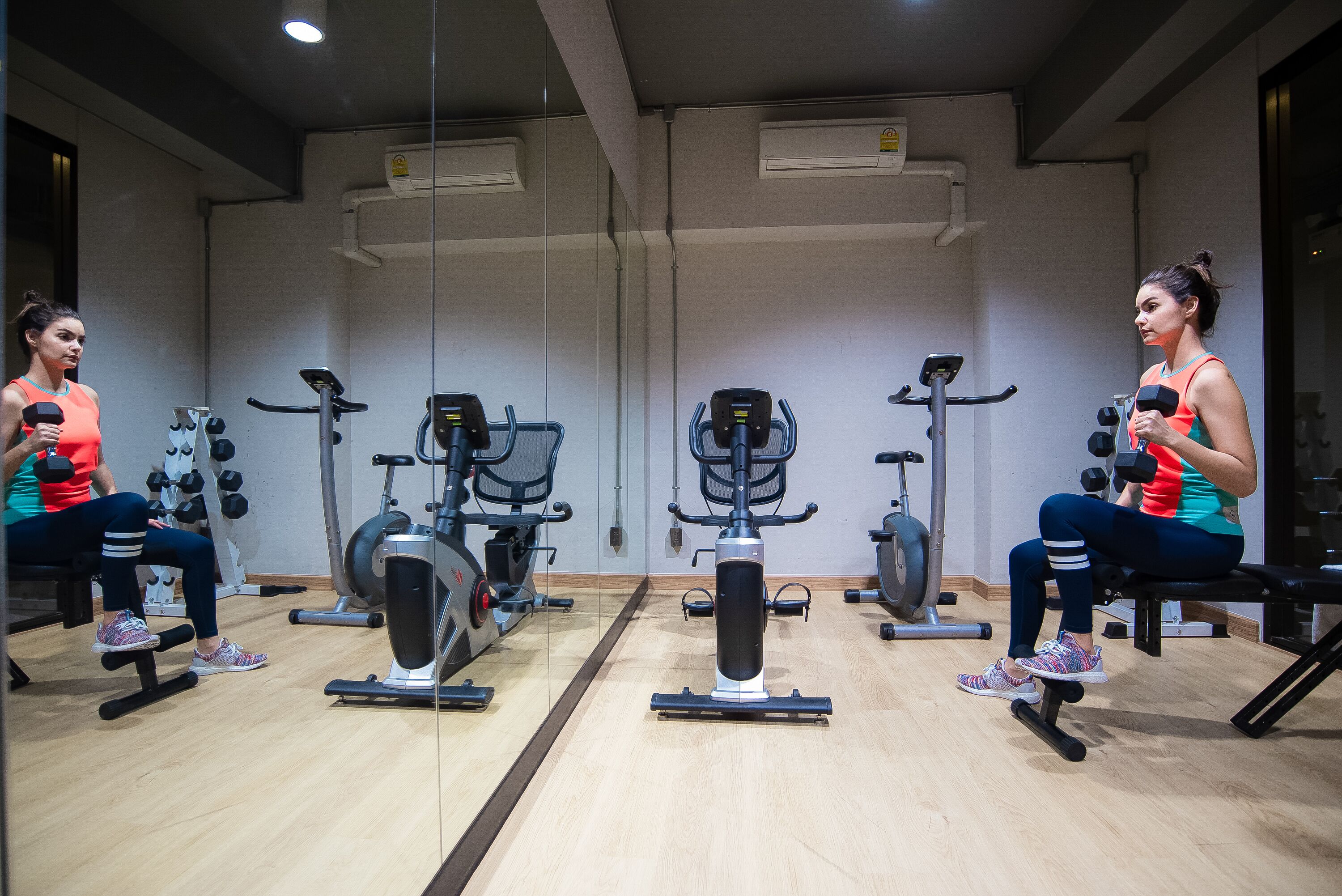 A gym with exercise equipment, including treadmills, stationary bikes, and weight machines.