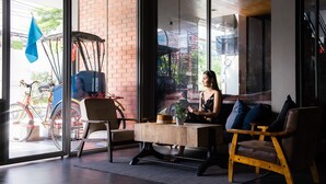 A modern interior with a large window, a wooden table, and two chairs. - THA City Loft by TH District (Bangkok)