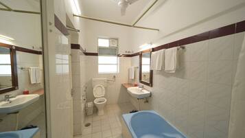 A bathroom with a toilet, sink, and bathtub.