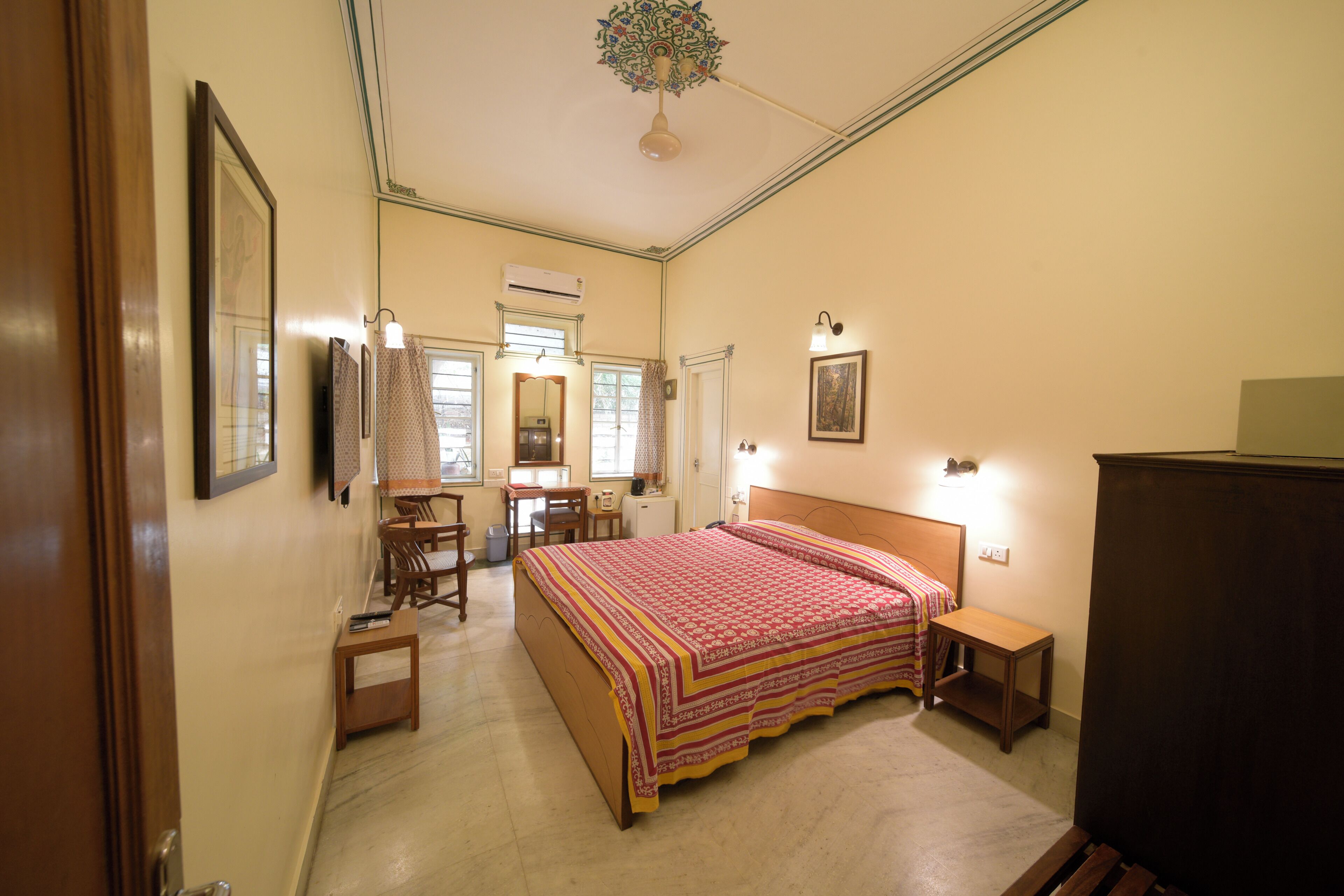 Une chambre à coucher avec un lit, des tables de chevet, un bureau et une chaise.