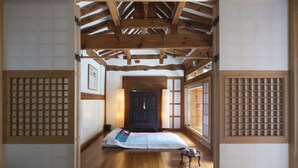 A traditional Japanese room with tatami flooring, a shoji screen door, and a dark wooden cabinet. - Xiwoo Hanok Guesthouse (Seoul)