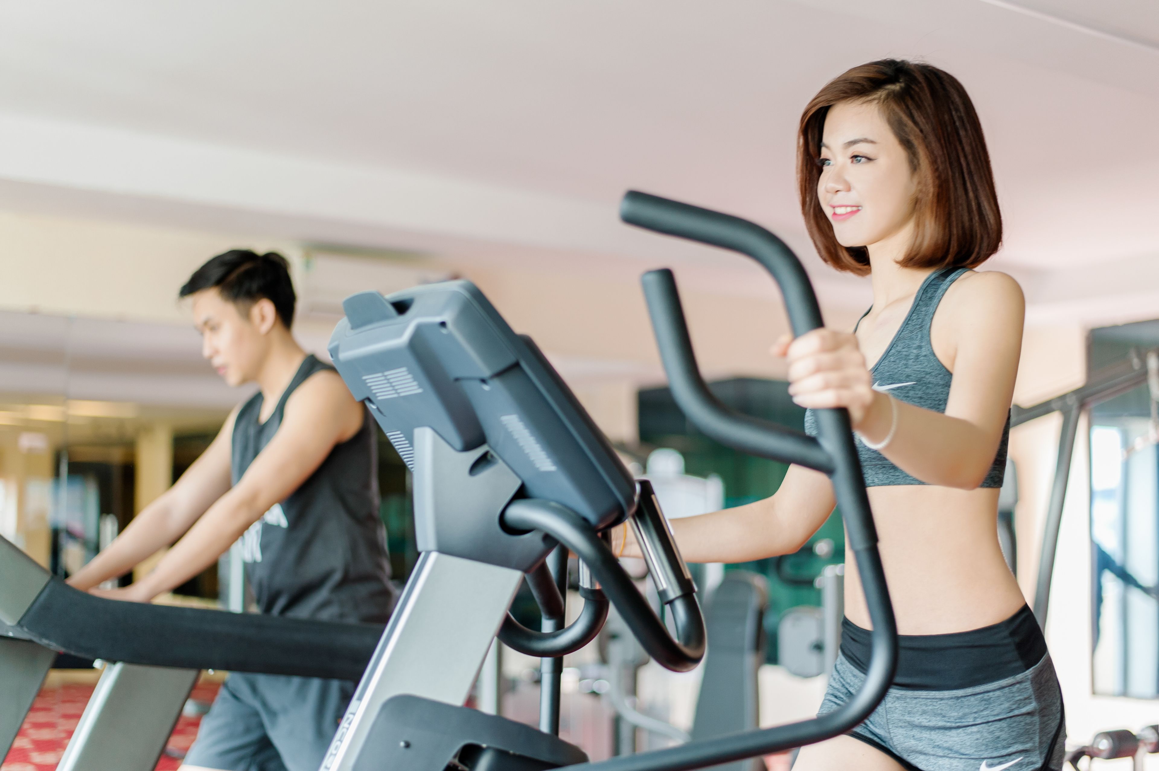 Un gimnasio con cintas de correr y equipo de ejercicio.