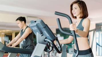 Un gimnasio con cintas de correr y equipo de ejercicio.