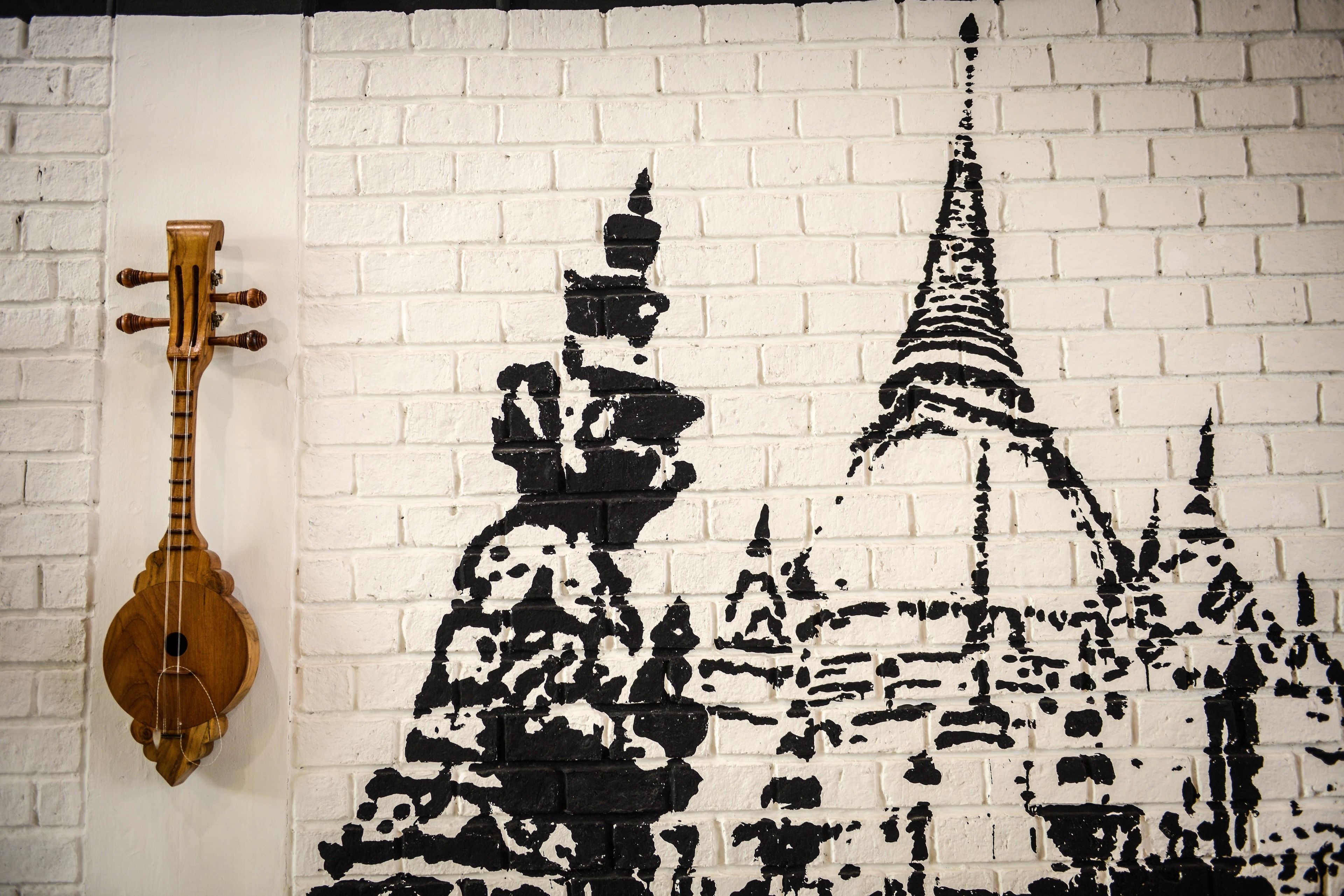 Pared con un diseño de ladrillo blanco y un mural blanco y negro de un templo.