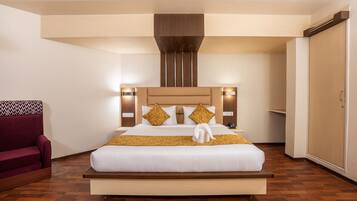 Una habitación de hotel moderna con una cama grande, un cabecero de madera y un sillón rojo.