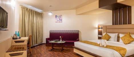 Una habitación de hotel con cama, sofá, escritorio y silla.