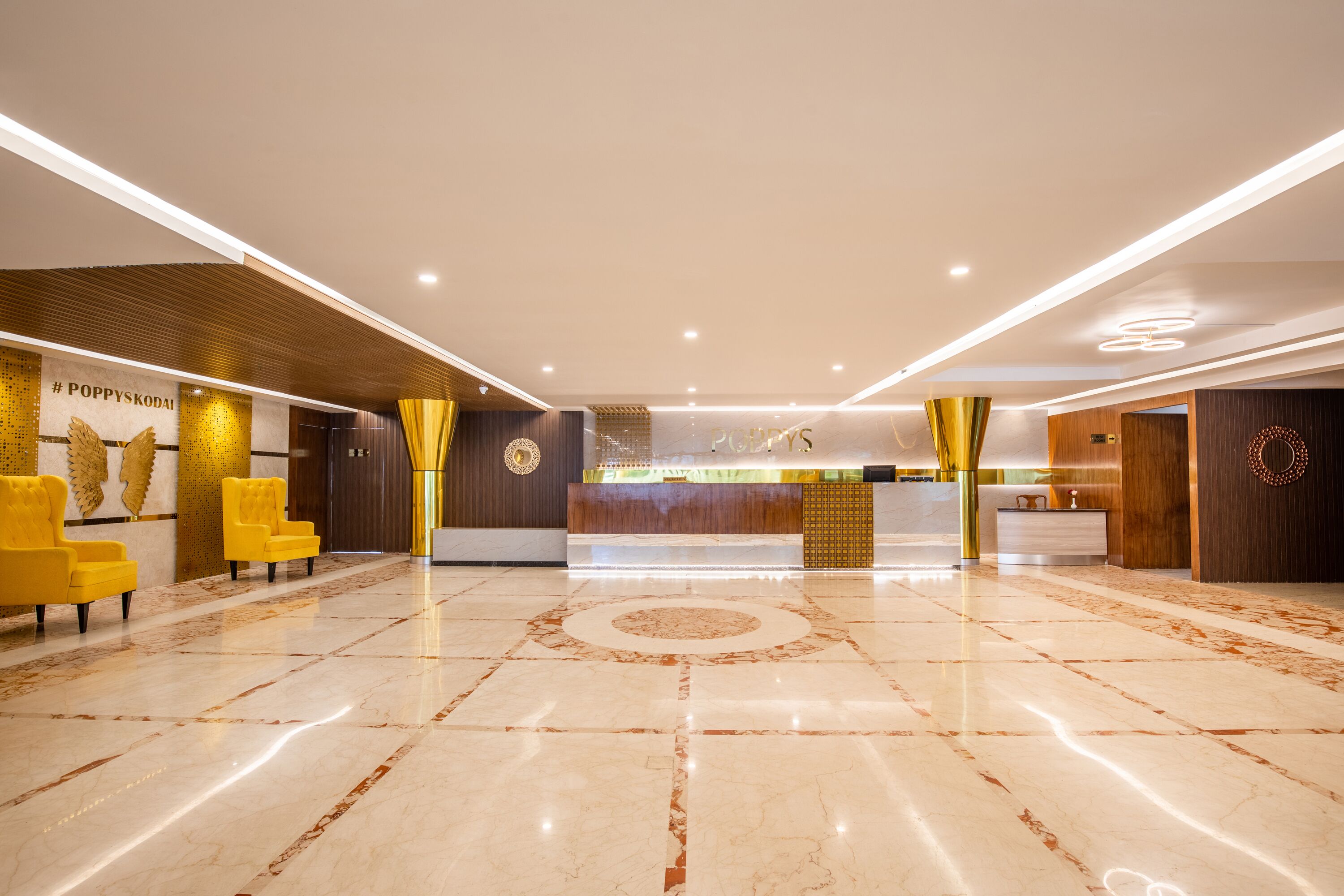 Una hall moderna di un hotel con pavimento in marmo, una reception e sedie gialle.