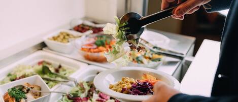A buffet with various dishes including salads and other food items.