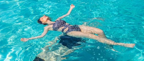 Una piscina al aire libre de temporada, sombrillas