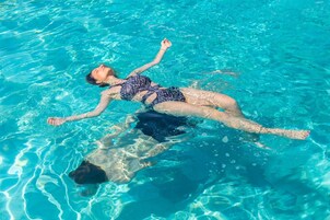Una piscina al aire libre de temporada, sombrillas